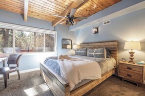 Un dormitorio con una cama de madera, un escritorio y una silla.