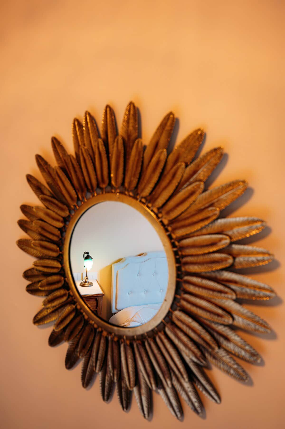 A wall-mounted mirror with a sunflower design.