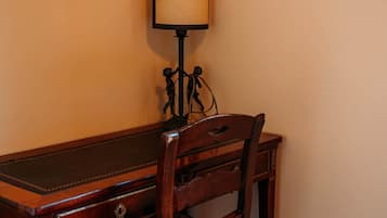Una scrivania in legno con una sedia, una lampada e un elemento decorativo al muro.