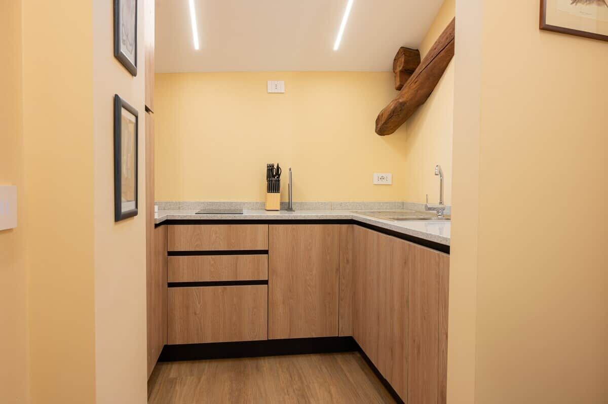 Une cuisine avec des meubles de rangement en bois, un plan de travail et un évier.