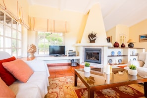A cozy living room with a fireplace, television, and comfortable seating. - Peaceful retreat w/ heatable pool, Portimão (Portimão)