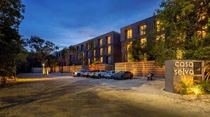 A modern building with a sign reading 'casa selva' and a parking area with several vehicles. - Ramada Residences by Wyndham Tulum (Tulum)
