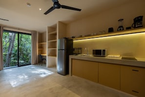 Una cocina moderna con refrigerador, microondas y cafetera integrados.