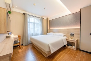 A modern hotel room with a wooden floor, a bed with white linens, a desk with a chair, a bedside table with a lamp, and a large window with curtains. - Winsome Hotel Guangzhou Tianhe Huajing Road Metro Branch (Shenzhen)