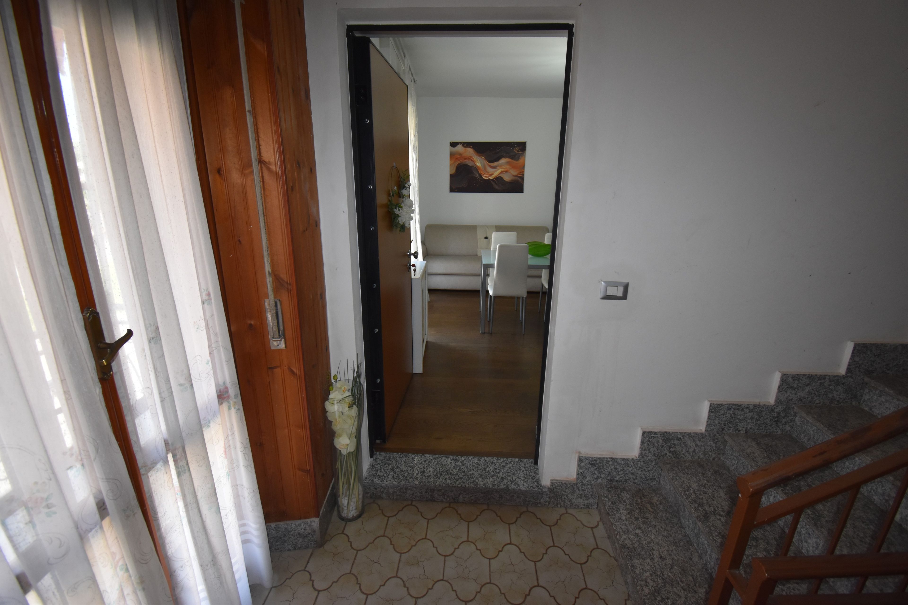 Eine Treppe führt zu einem Wohnbereich mit einer Couch und einem Esstisch.
