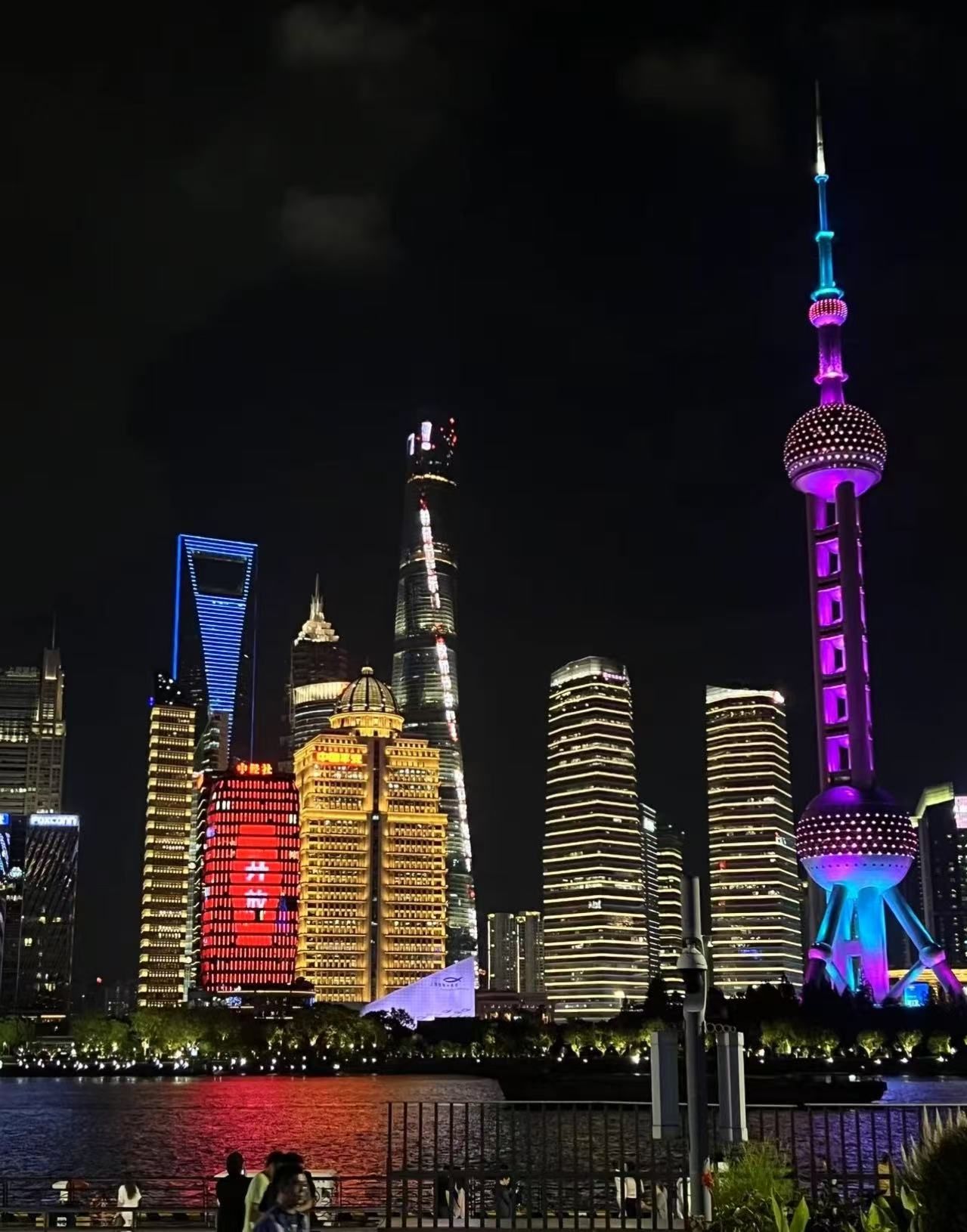 A city skyline with illuminated buildings and a prominent tower with a spherical observation deck.
