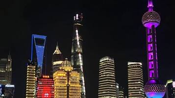 A city skyline with illuminated buildings and a prominent tower with a spherical observation deck.