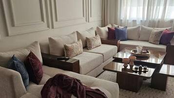 A modern living room with a sofa set, a coffee table, and a decorative rug.