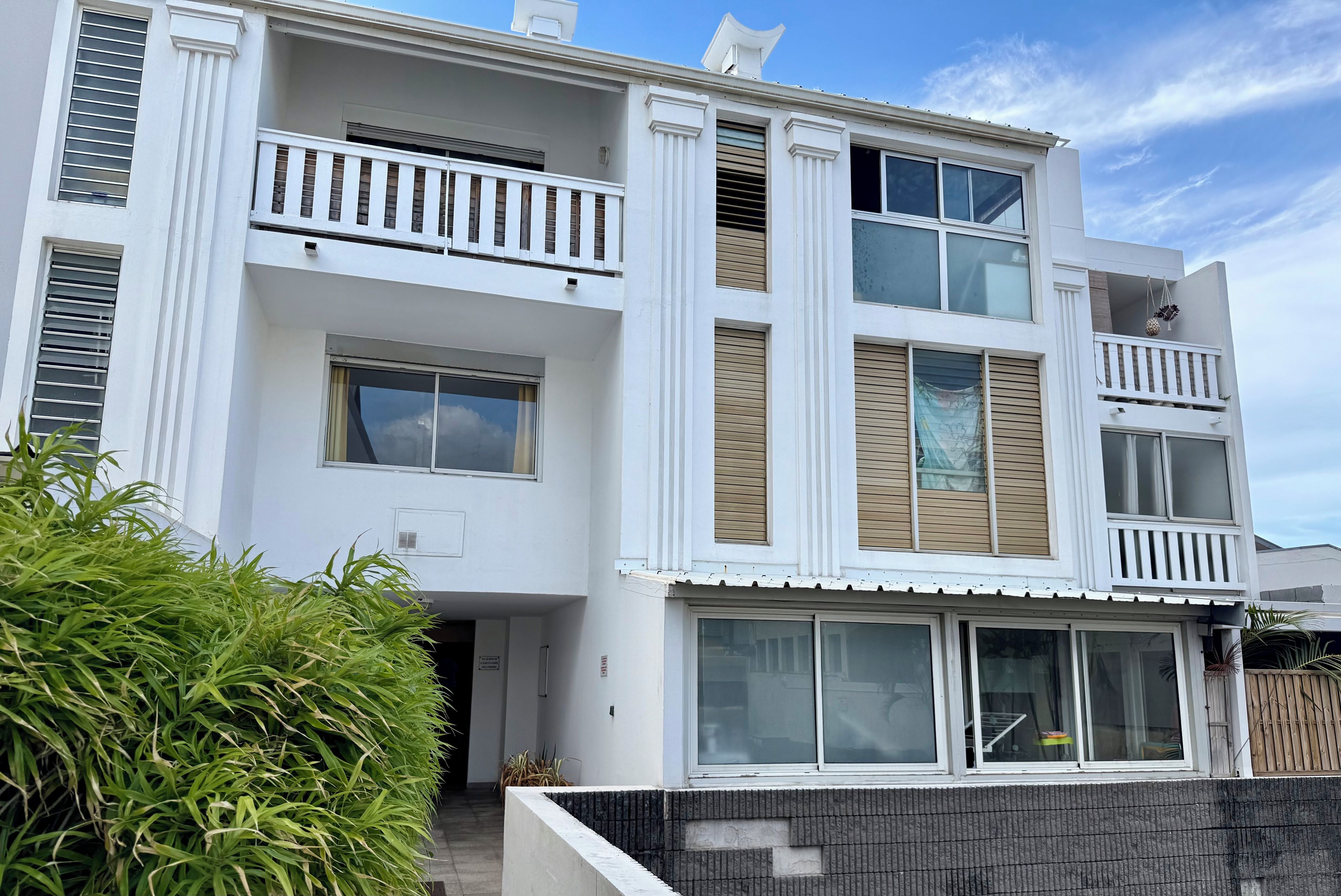 A multi-story residential building with balconies, large windows, and a modern architectural design.