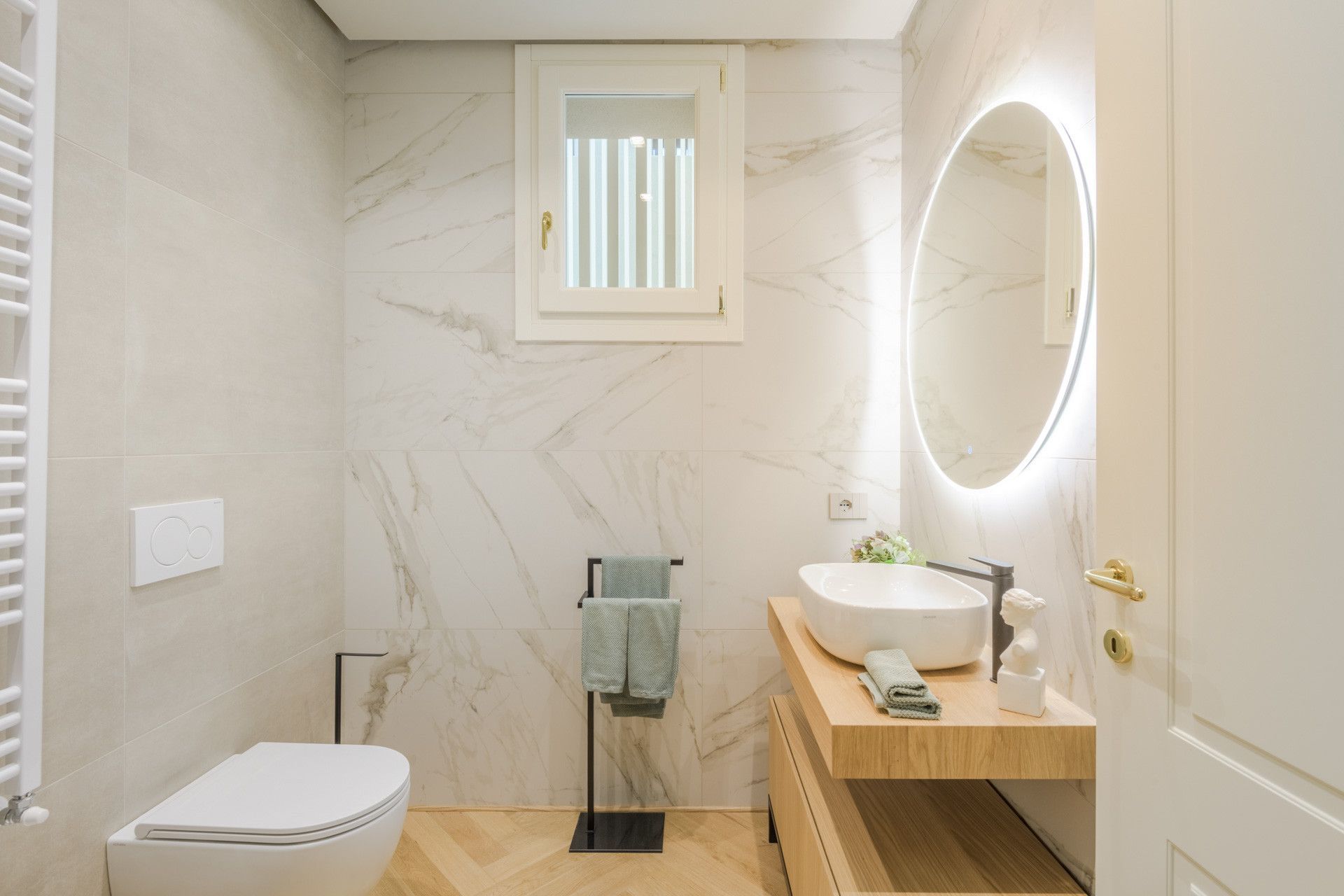 A modern bathroom with a toilet, sink, and mirror.