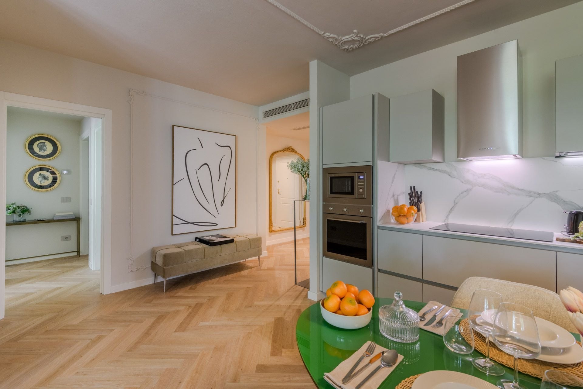 Une cuisine moderne équipée d’un four à micro-ondes encastré, d’un four traditionnel et d’une hotte en acier inoxydable.