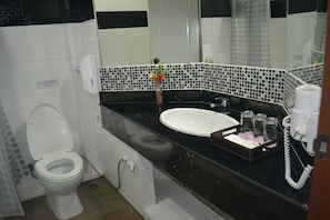 Une salle de bain avec des toilettes, un lavabo et un miroir.