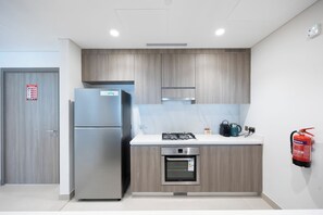 A modern kitchen with a built-in refrigerator, oven, and gas stove. - G04- Bloomfields 2BR in Fairways 1- YGC (Abu Dhabi)