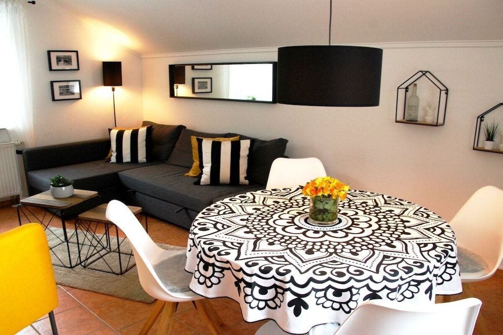 Un salon moderne avec une table de salle à manger ronde, un canapé et une table basse.