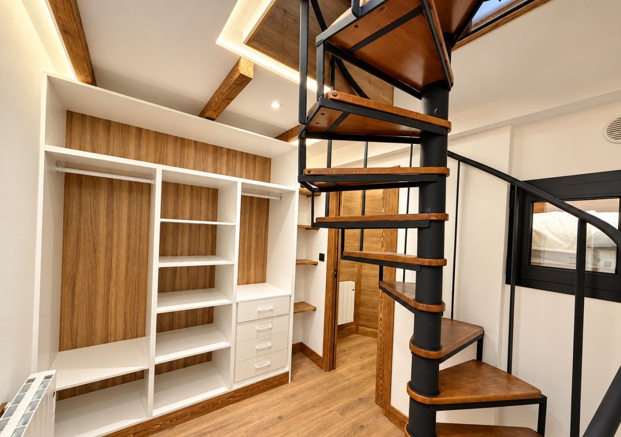 Un intérieur moderne avec un escalier en colimaçon, des étagères en bois intégrées et un radiateur.