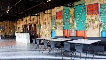 A restaurant with a bamboo wall decor, tables, and chairs.