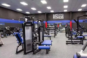 Una palestra con diverse attrezzature per esercizi, tra cui macchinari per pesi e panche.