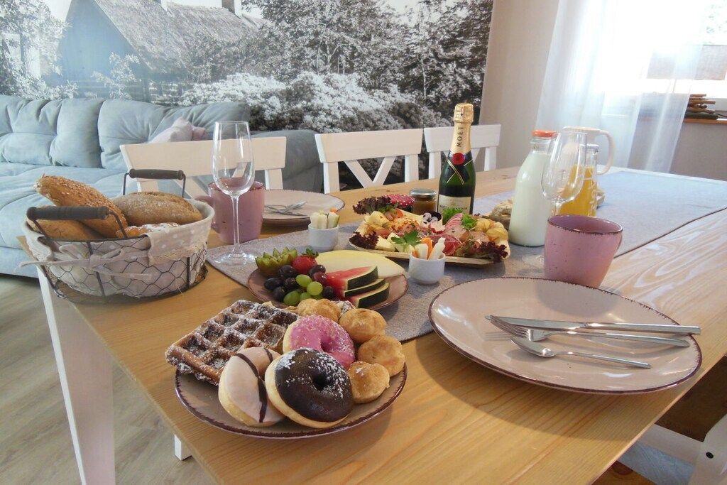 Una mesa de comedor con diversos alimentos, una botella de champán y una copa de vino.