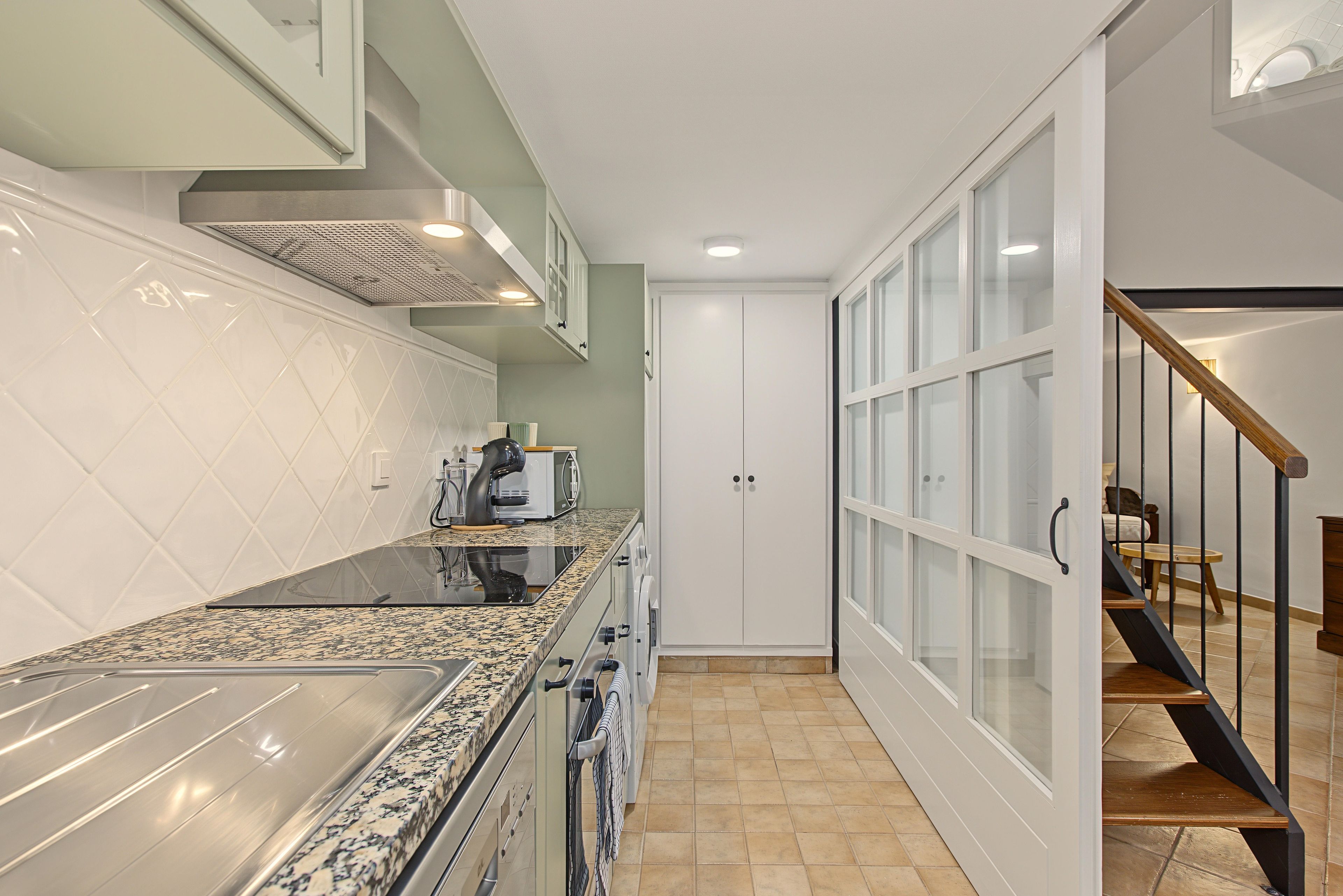 A modern kitchen with a granite countertop, stainless steel appliances, and a built-in oven.