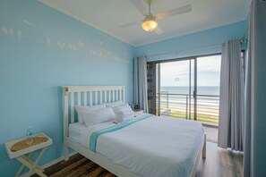 A bedroom with a bed, a nightstand, a ceiling fan, and a view of the ocean. - "Serene Shores" Ocean View Luxury in Durban, South Africa (Kingsburgh)