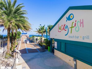 Un bar et restaurant de plage appelé Lucky Fish, offrant une vue sur l’océan et les palmiers.