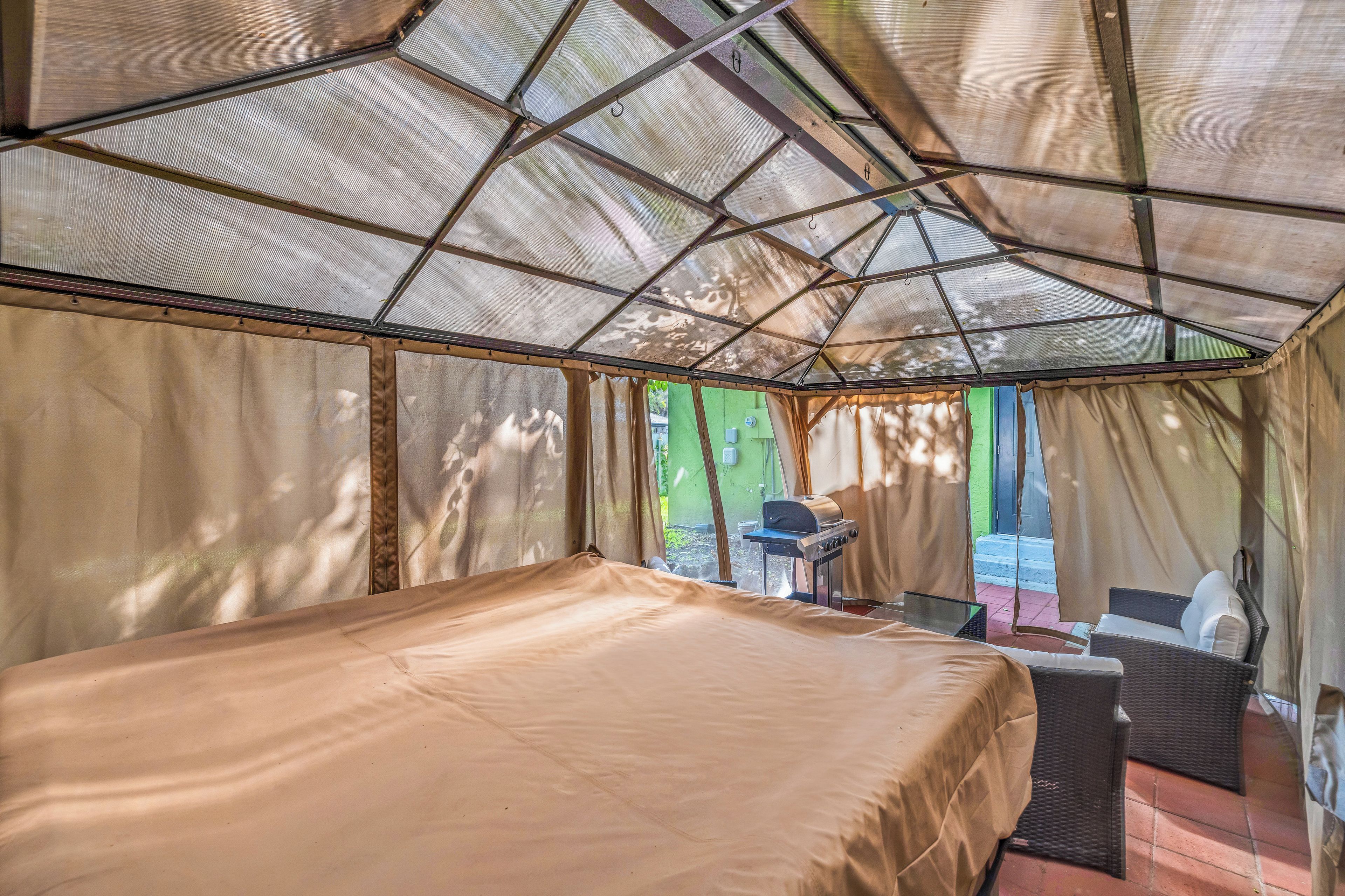 A tented accommodation with a bed, a table, and a chair.
