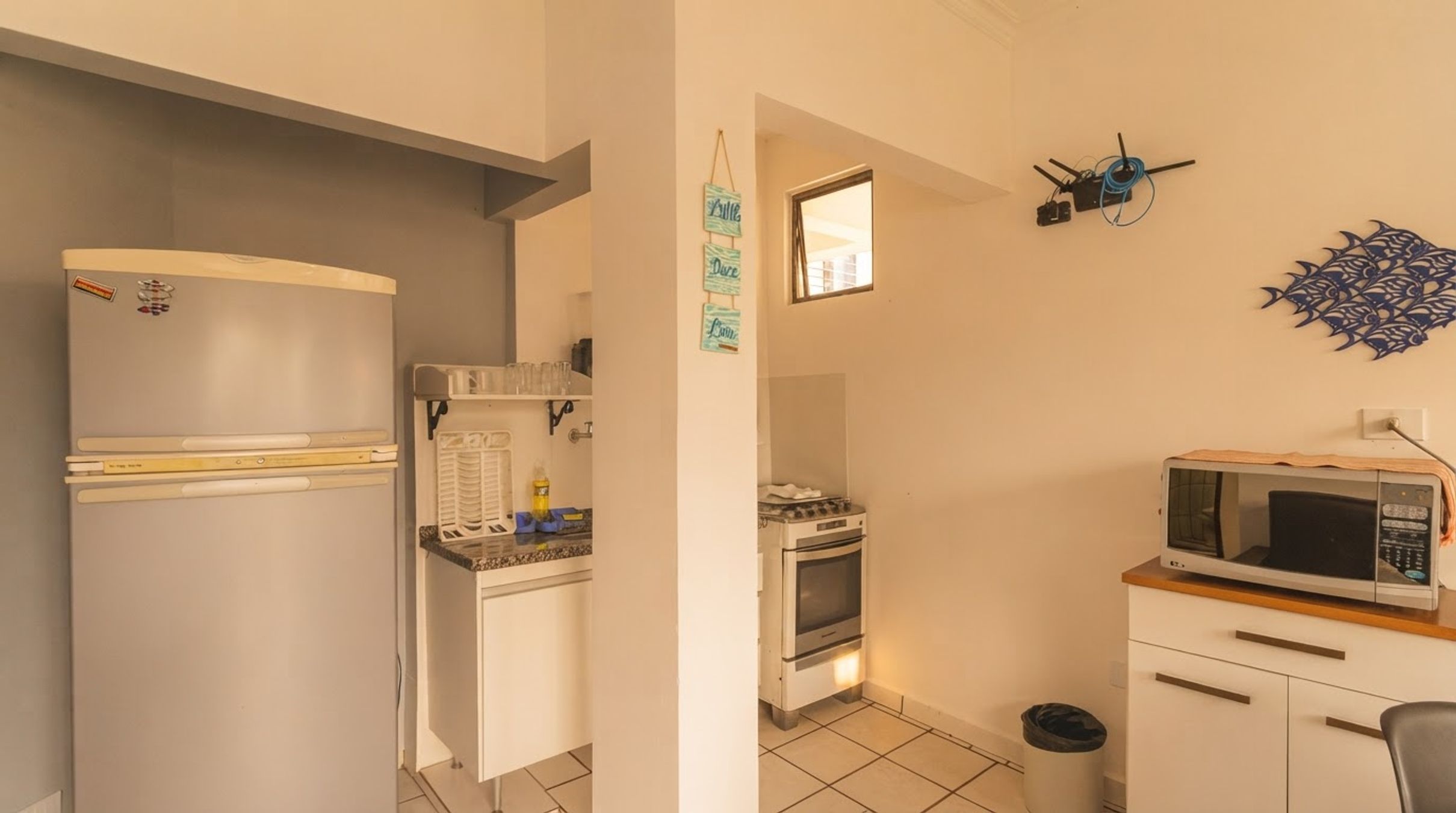 A compact kitchen with a refrigerator, oven, microwave, and a small countertop.