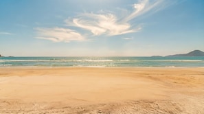 A beach with a clear sky and calm sea. - Apartment with BBQ and Garage in Praia Grande (Ubatuba)