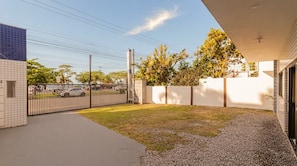Una propietat residencial amb un vial pavimentat, un pati tancat i una paret exterior blanca.