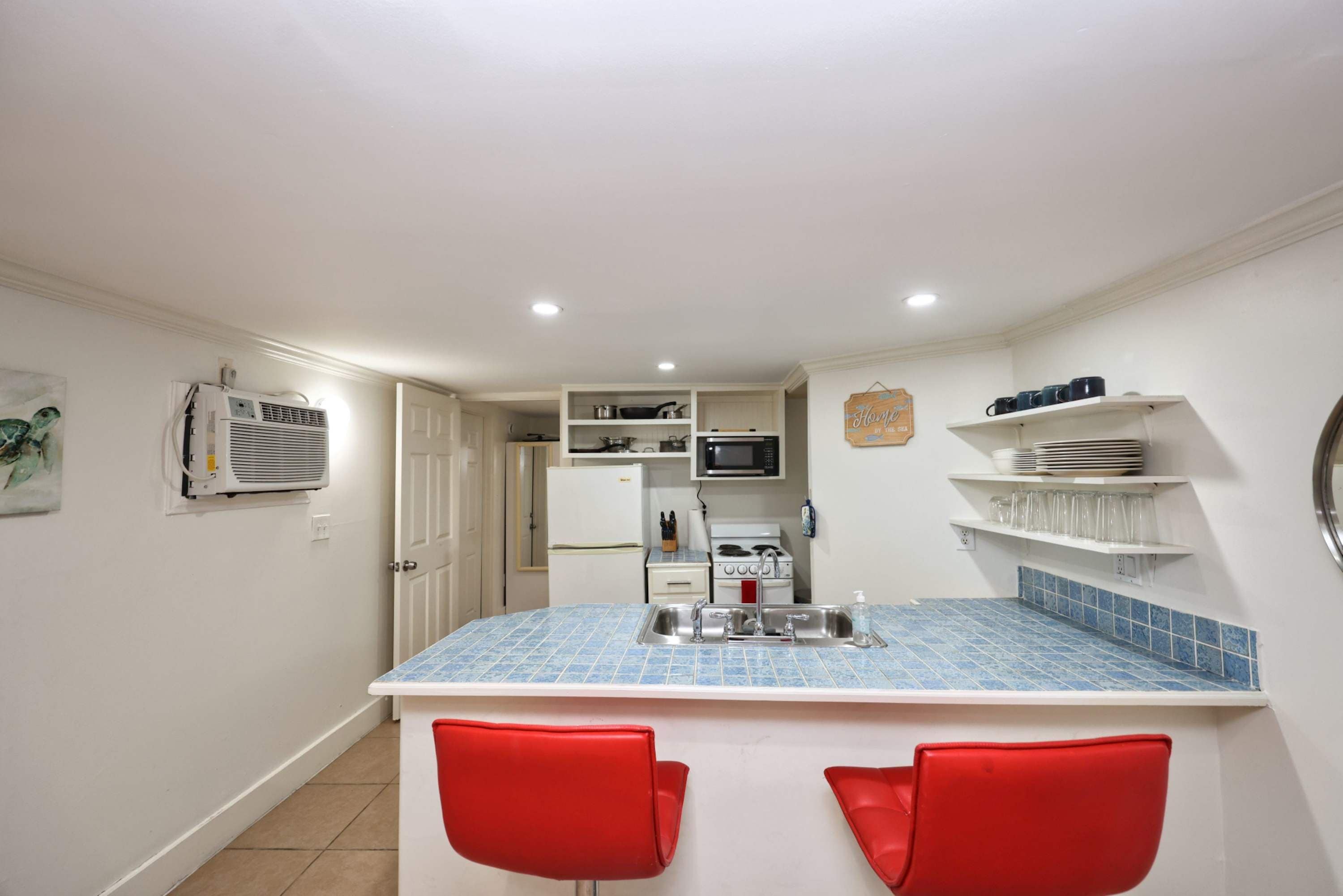 A compact kitchen with a central island, a microwave, and a refrigerator.
