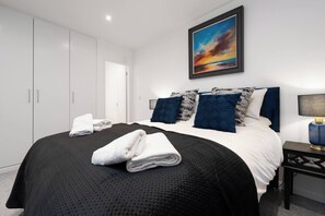A bedroom with a bed, pillows, a nightstand, a lamp, and a painting on the wall. - Brighton St Merseyside 2-Bed/Sleeps 6 Wifi/Parking (Merseyside)