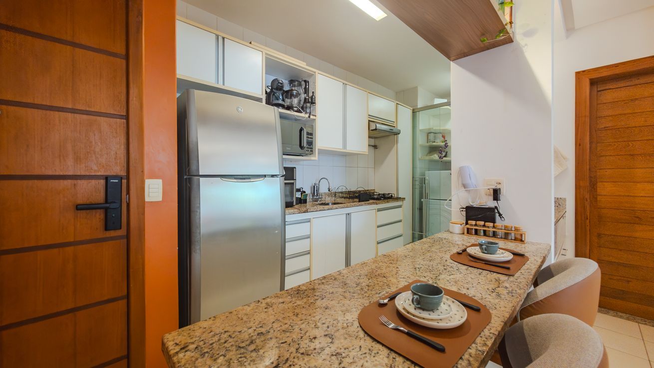 A modern kitchen with a built-in oven, microwave, and stainless steel refrigerator.