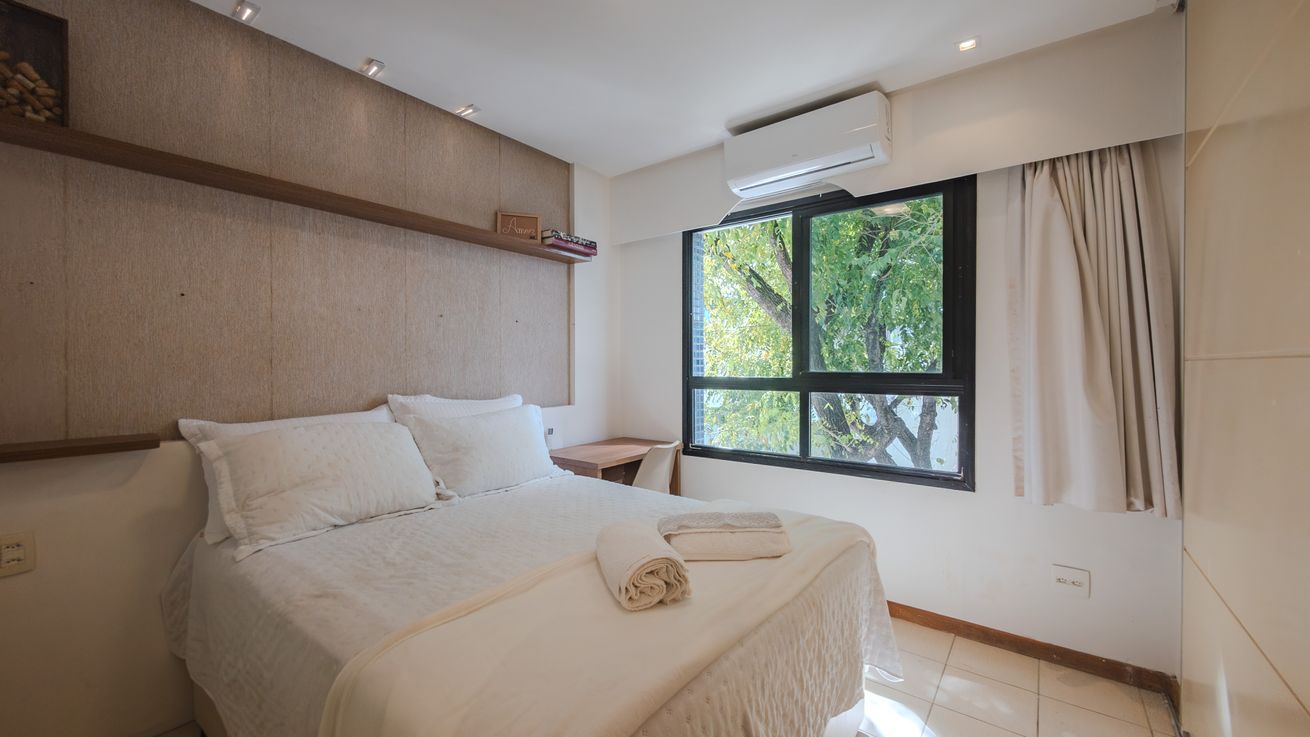 Une chambre à coucher avec un lit, une fenêtre et une table de chevet.