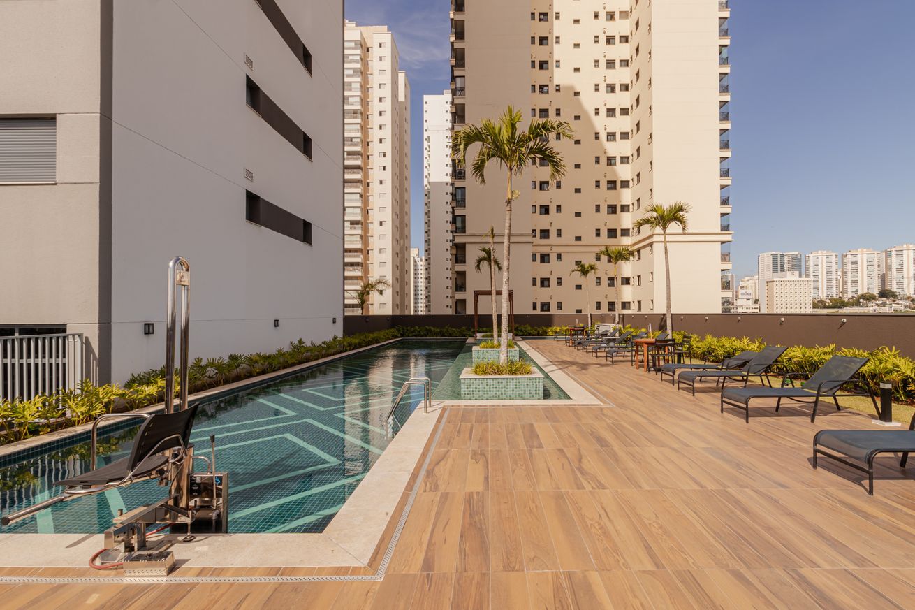 A rooftop pool area with lounge chairs and a diving board.