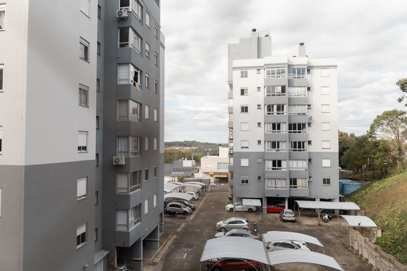 A multi-story residential building with parking in front.