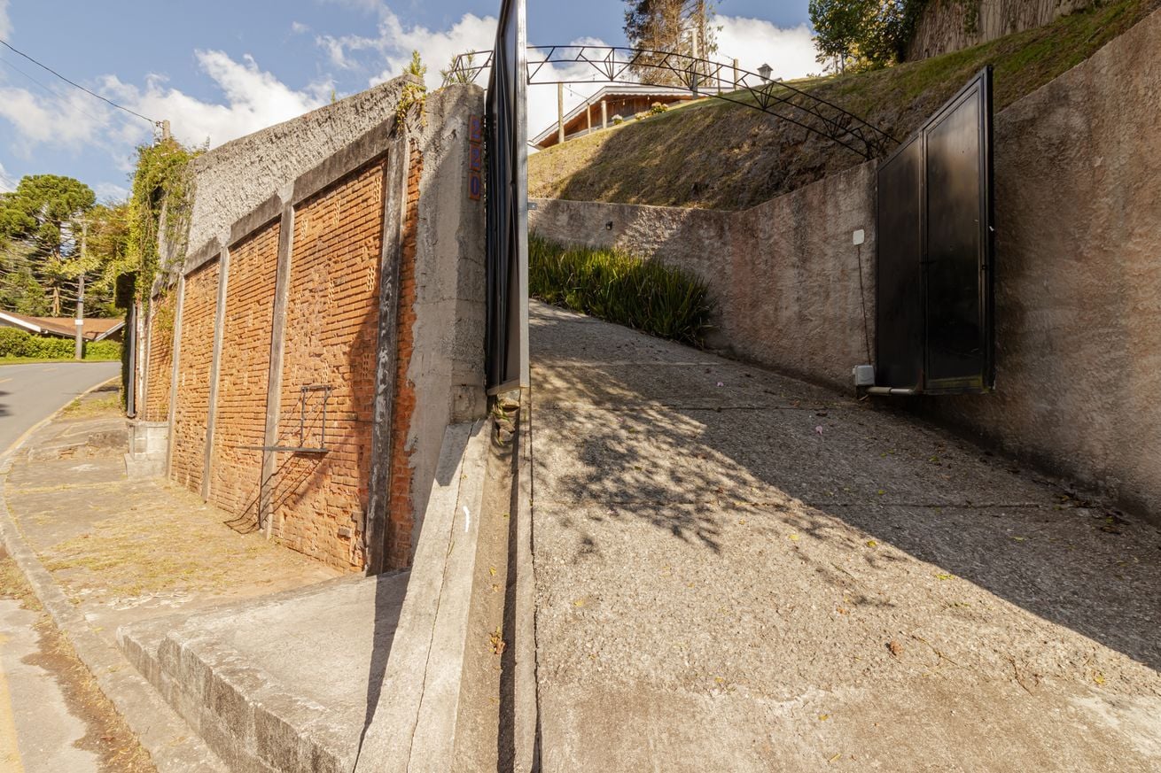 A building with a brick exterior, a concrete pathway, and a metal door.