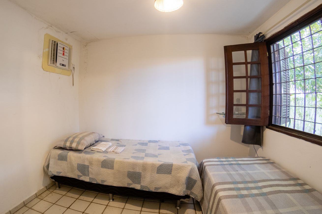 Un piccolo alloggio con una sola stanza, un letto, una finestra vista e un termostato a parete.