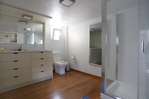 A modern bathroom with a shower, toilet, and vanity.