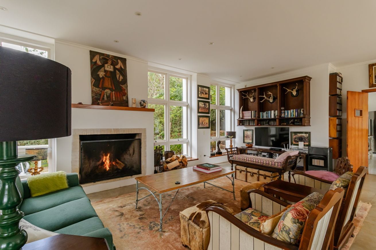 A spacious living room with a fireplace, a large bookshelf, and a cozy seating area.