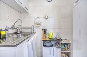 Eine Küche mit Spüle, Abtropfgestell, einem Messerset und einem Geschirrgestell.
