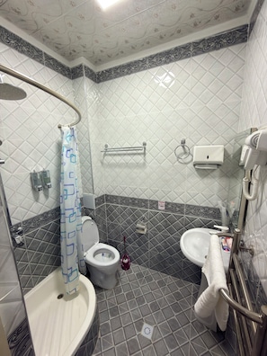 A bathroom with a shower, toilet, bidet, and sink. - Bekchan Hotel (Xiva)