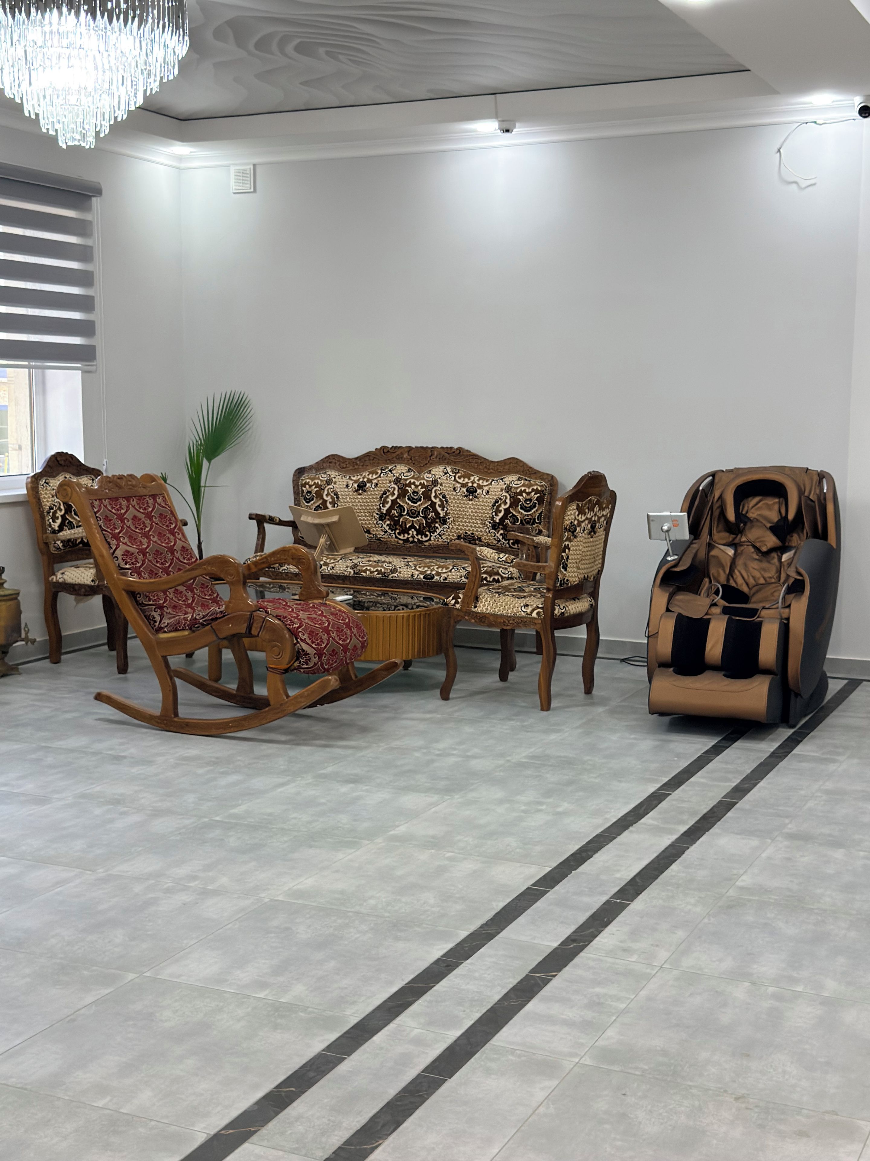 Una sala de estar con sofá, mecedora y sillón de masaje.