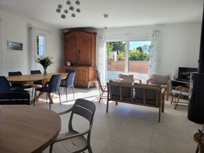 Un grand espace de vie comprenant une table à manger, des chaises, un canapé et un téléviseur.