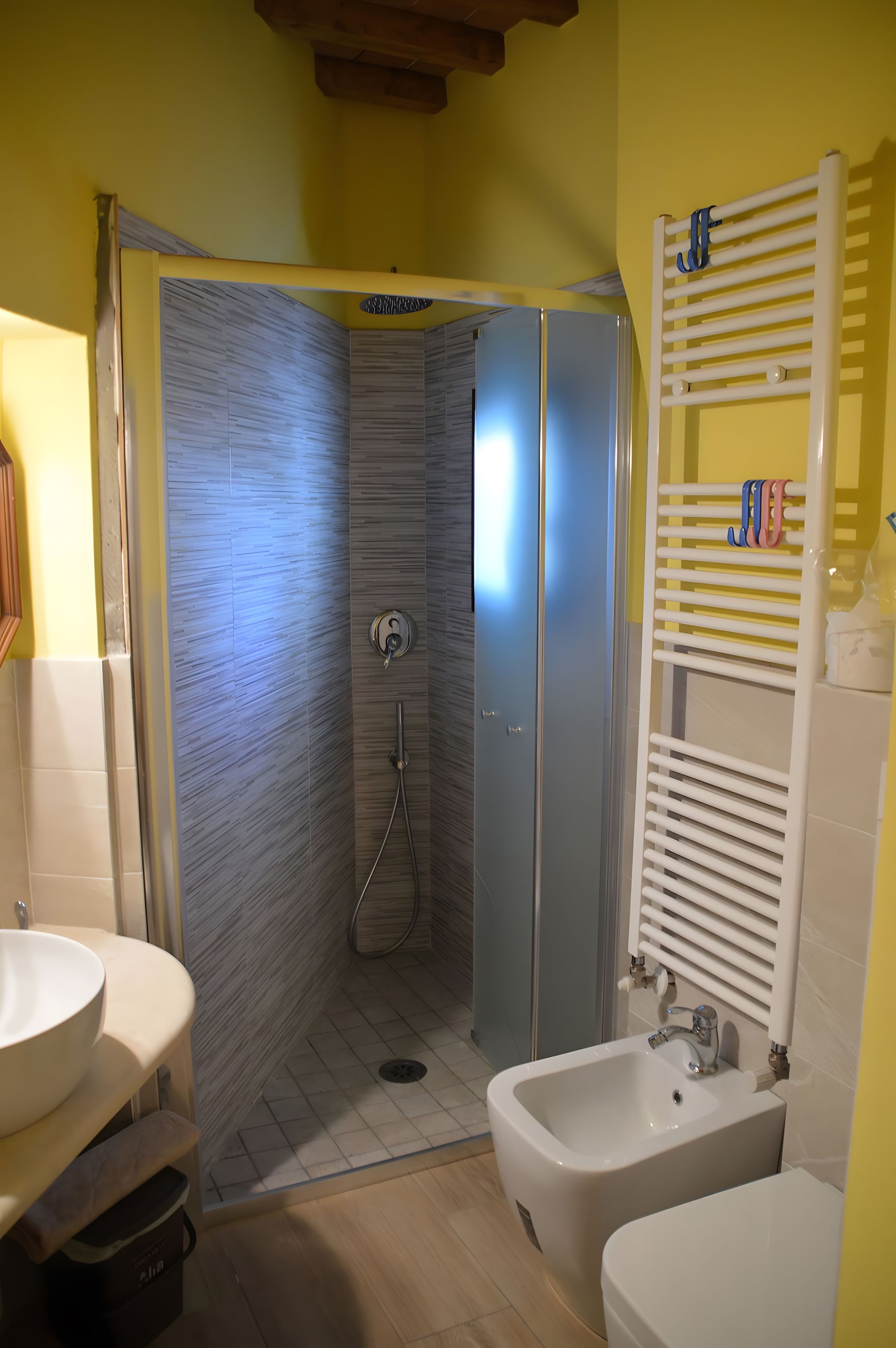 Et badeværelse med bruser, håndvask og toiletbidé.
