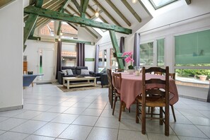 A dining area with a table set for four, surrounded by wooden chairs. - Accessible Holiday Home for 6–8 near Colmar – Vallée Noble, Terrace, Free Parking (Osenbach)