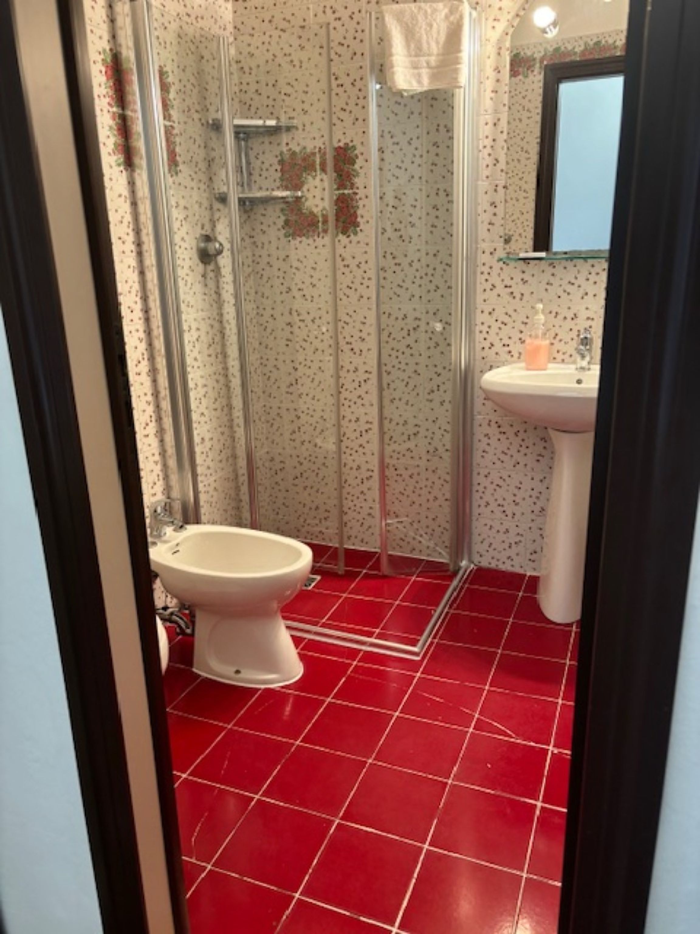 A bathroom with a shower, toilet, and sink.
