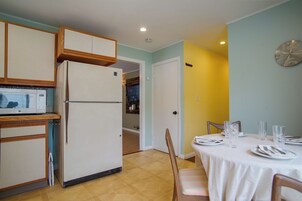 Una cocina compacta con refrigerador, microondas y armarios de madera.