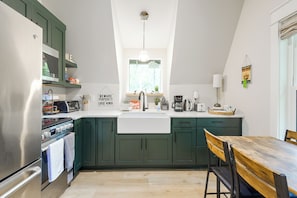 A kitchen with a built-in oven, a coffee maker, and a sink.