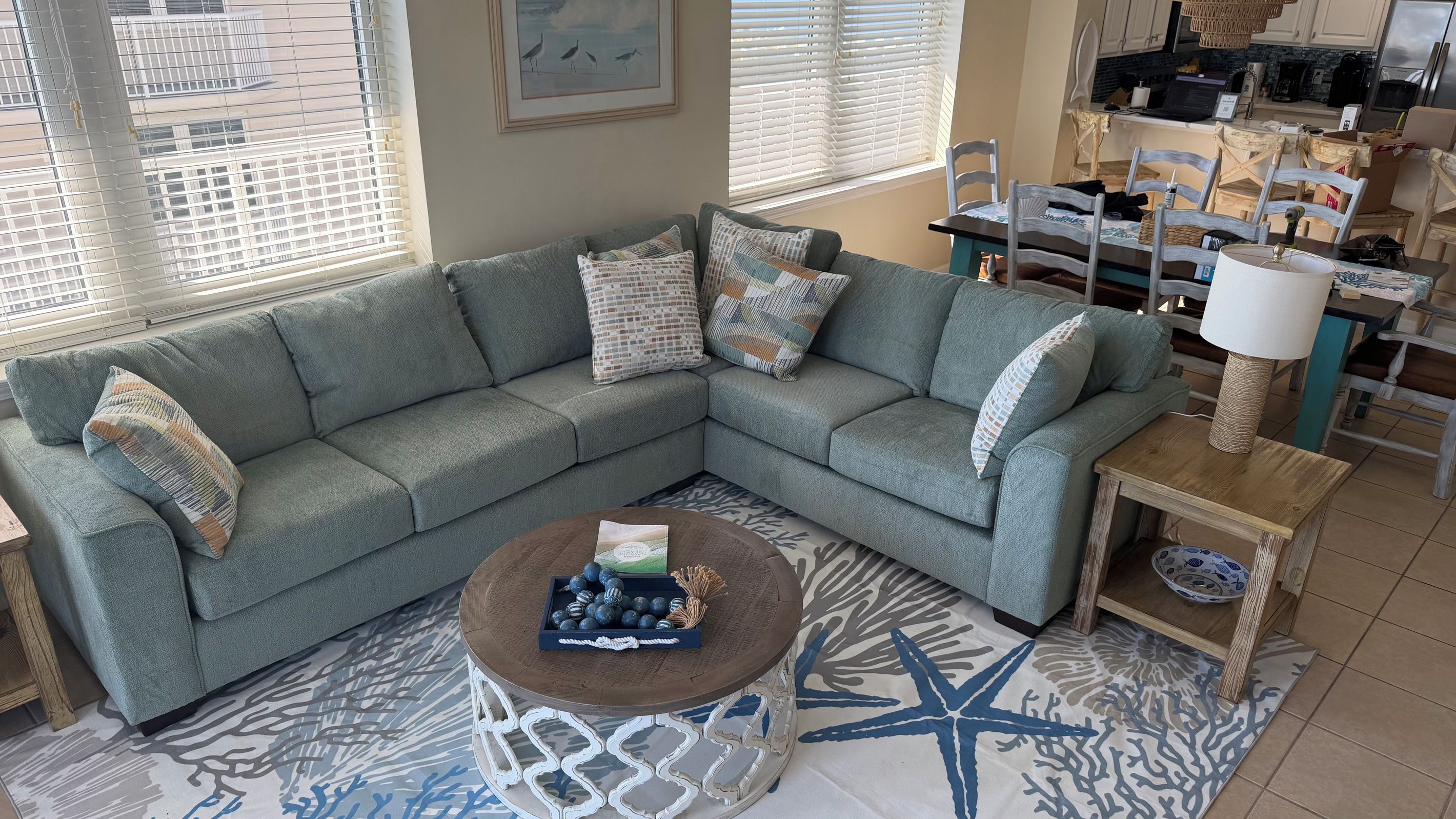 A living room with a sectional sofa, a coffee table, and a patterned rug.