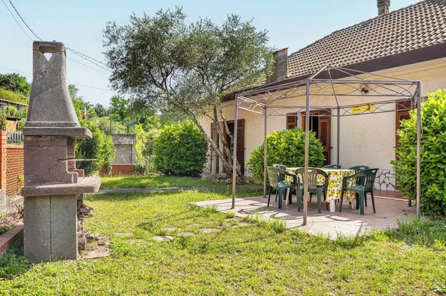 A patio with outdoor furniture, a stone structure, and a building with a tiled roof.